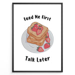 Ladda upp bild till gallerivisning, Funny kitchen poster with a plate of toast and strawberries, and the text “Feed Me First Talk Later,” framed in black on a white background.
