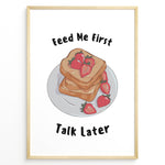 Ladda upp bild till gallerivisning, Funny kitchen poster with a plate of toast and strawberries, and the text “Feed Me First Talk Later,” framed in black on a white background.

