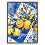Ladda upp bild till gallerivisning, Mediterranean lemon wall art with yellow lemons and olive leaves on blue and white tile background, framed in black, ideal for kitchen or dining room décor.
