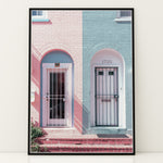 Ladda upp bild till gallerivisning, Plakat med farverige døre | Sommer og Strand Plakater | Denne plakat viser en pink og en blå dør side om side, hver i en buet dørkarm, på en farverig bygning. Perfekt til dem, der elsker unik arkitektur.

