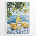 Ladda upp bild till gallerivisning, Limoncello art print plakat with a bottle of limoncello, lemons, and green leaves overlooking the blue sea on a striped tablecloth in a white frame.
