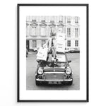 Ladda upp bild till gallerivisning, Fashion Plakat | Chanel Shopping Woman Plakaty.dk | Fashion plakat shopping i Paris | Kvinde i blazer og hæle sidder på bil med Chanel-poser foran klassisk bygning. Sort-hvid modefoto.
