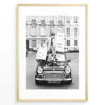 Ladda upp bild till gallerivisning, Fashion Plakat | Chanel Shopping Woman Plakaty.dk | Fashion plakat shopping i Paris | Kvinde i blazer og hæle sidder på bil med Chanel-poser foran klassisk bygning. Sort-hvid modefoto.
