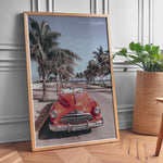 Ladda upp bild till gallerivisning, Plakat med vintage rød bil | Sommer og Strand Plakater | Denne plakat viser en klassisk rød cabriolet parkeret på en gade med palmer ved stranden. Perfekt til retro- og strandelskere.
