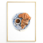 Ladda upp bild till gallerivisning, Watercolor wall art of a croissant and espresso cup on a blue decorative plate, ideal for French café, kitchen, or breakfast nook wall décor.

