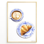 Ladda upp bild till gallerivisning, Art print of a cappuccino and croissant on blue patterned plates — French café-style kitchen wall décor.
