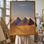 Ladda upp bild till gallerivisning, Cairo Vintage Travel Plakat | Vintage Travel Poster | Denne plakat viser de ikoniske Giza-pyramider i Cairo, Egypten, mod en gradient himmel og et ørkenlandskab.
