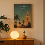 Ladda upp bild till gallerivisning, Marrakech Vintage Travel Plakat | Vintage Travel Poster | Denne plakat viser en stiliseret illustration af Marrakech med en høj minaret og palmetræer mod en gradienthimmel.
