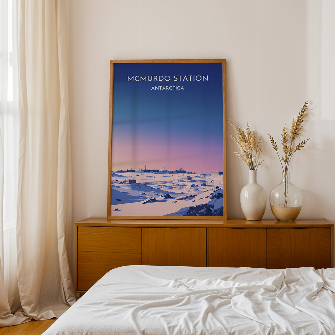 McMurdo Station Vintage Travel Plakat | Vintage Travel Poster | Denne plakat viser en stiliseret illustration af McMurdo Station i Antarktis med en gradienthimmel og snebeklædte bygninger. Perfekt til rejse- og historieentusiaster.