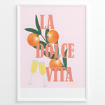 Ladda upp bild till gallerivisning, Stylish La Dolce Vita poster with oranges, green leaves, and champagne glasses on a pink background, framed as Italian-inspired wall art.
