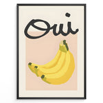Ladda upp bild till gallerivisning, Modern art poster featuring the word “Oui” in bold black text above a bunch of yellow bananas on a soft pink background, framed as French kitchen wall décor.
