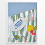 Ladda upp bild till gallerivisning, Mediterranean still life poster with fish on a white plate, lemon, radishes, olives, and a pink drink on a green and white striped tablecloth, framed as kitchen wall art.
