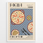 Ladda upp bild till gallerivisning, Vintage Spanish paella poster with illustrated pan of rice, prawns, and lemon slices on a blue patterned background in a white frame.
