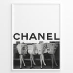 Ladda upp bild till gallerivisning, Fashion Plakat | CHANEL Newspaper Bench – Fashion Art Poster Plakaty.dk | Black and white fashion poster of four women sitting on a bench reading newspapers, with the bold text &quot;CHANEL&quot; across the top half of the image.
