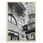Ladda upp bild till gallerivisning, Fashion Plakat | Chanel Boutique Vienna Black &amp; White Architectural Poster Plakaty.dk | Black and white photo of a Chanel store in a European city with ornate architecture and a Chanel flag sign.
