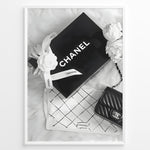 Ladda upp bild till gallerivisning, Fashion Plakat | Chanel Gift Box &amp; Handbag Flatlay Wall Art Plakaty.dk | Black and white flatlay of a Chanel gift box with ribbon, camellia flowers, and a quilted Chanel handbag on a soft surface.
