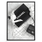 Ladda upp bild till gallerivisning, Fashion Plakat | Chanel Gift Box &amp; Handbag Flatlay Wall Art Plakaty.dk | Black and white flatlay of a Chanel gift box with ribbon, camellia flowers, and a quilted Chanel handbag on a soft surface.
