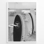 Ladda upp bild till gallerivisning, Fashion Plakat | Chanel Surfboards on the Beach – Luxury Meets Coastal Lifestyle in Black and White Plakaty.dk | Black and white photo of Chanel and J12 Yacht Club surfboards on a sandy beach with umbrellas and lounge chairs in the background
