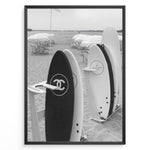 Ladda upp bild till gallerivisning, Fashion Plakat | Chanel Surfboards on the Beach – Luxury Meets Coastal Lifestyle in Black and White Plakaty.dk | Black and white photo of Chanel and J12 Yacht Club surfboards on a sandy beach with umbrellas and lounge chairs in the background

