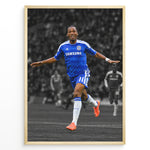 Ladda upp bild till gallerivisning, Didier Drogba i Chelsea-trøje med armene strakt ud under en fodboldfejring. Motivet har en sort-hvid stadionbaggrund med fremhævede blå og orange farver.

