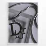 Ladda upp bild till gallerivisning, Fashion Plakat | Dior Pendant Necklace – Elegant Black &amp; White Fashion Print Plakaty.dk | Black and white close-up image of a Dior pendant necklace with a metallic chain, showcasing luxury jewelry on a textured background.
