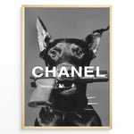 Ladda upp bild till gallerivisning, Fashion Plakat | Edgy Chanel-Inspired Art Featuring Dog with Gun Plakaty.dk | Black dog with spiked collar holding a handgun in its mouth, with the word &quot;CHANEL&quot; overlaid in bold white text.
