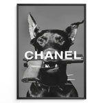 Ladda upp bild till gallerivisning, Fashion Plakat | Edgy Chanel-Inspired Art Featuring Dog with Gun Plakaty.dk | Black dog with spiked collar holding a handgun in its mouth, with the word &quot;CHANEL&quot; overlaid in bold white text.
