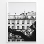 Ladda upp bild till gallerivisning, Fashion Plakat | Elegant Woman Relaxing on Parisian Balcony – Black and White Photography Plakaty.dk | Black and white photo of a woman relaxing on a Parisian balcony with classic building architecture in the background
