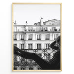 Ladda upp bild till gallerivisning, Fashion Plakat | Elegant Woman Relaxing on Parisian Balcony – Black and White Photography Plakaty.dk | Black and white photo of a woman relaxing on a Parisian balcony with classic building architecture in the background
