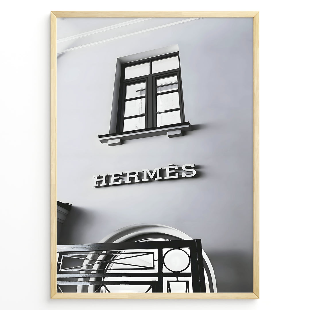 Fashion Plakat | Hermès Storefront Minimalist Poster – Black & White Fashion Wall Art Plakaty.dk | Black and white photo of the Hermès storefront with a clean minimalist facade, showing a window above the iconic logo and part of an ornate entryway gate.
