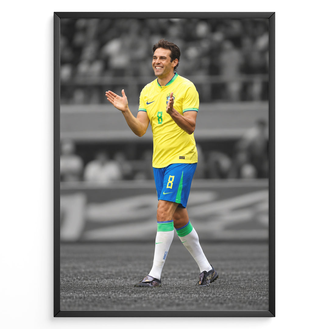 Kaká iført Brasiliens gule fodboldtrøje på en stilren sort-hvid fodboldbane.