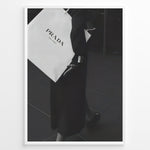 Ladda upp bild till gallerivisning, Fashion Plakat | Prada Shopping Bag Fashion Photography Wall Art Plakaty.dk | Black and white photo of a person holding a large Prada Milano shopping bag, dressed in elegant dark clothing.
