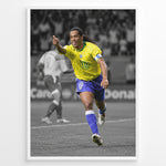 Ladda upp bild till gallerivisning, Ronaldinho wearing the iconic yellow Brazil football jersey with number 10 while celebrating on the pitch. A black and white background highlights the Brazilian colors.
