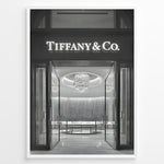 Ladda upp bild till gallerivisning, Fashion Plakat | Tiffany &amp; Co. Entrance – Luxury Jewelry Store Poster in Black &amp; White Plakaty.dk | Black and white photo of the Tiffany &amp; Co. boutique entrance with glass doors, a chandelier inside, and the illuminated brand name above.

