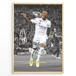 Ladda upp bild till gallerivisning, Framed plakat of Vinícius Jr. in a Real Madrid kit celebrating with a pointing gesture, color-highlighted against a black and white background with signature
